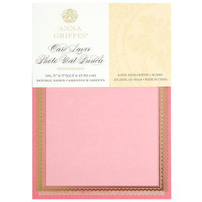 The Card Layer Photo Mat Bundle includes 5" x 7" pink and gold double-sided cardstock sheets, perfect for cardmaking and scrapbooking, shown in its packaging.
