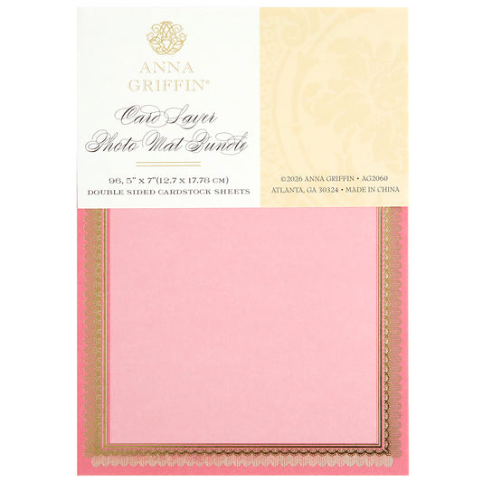 The Card Layer Photo Mat Bundle includes 5" x 7" pink and gold double-sided cardstock sheets, perfect for cardmaking and scrapbooking, shown in its packaging.