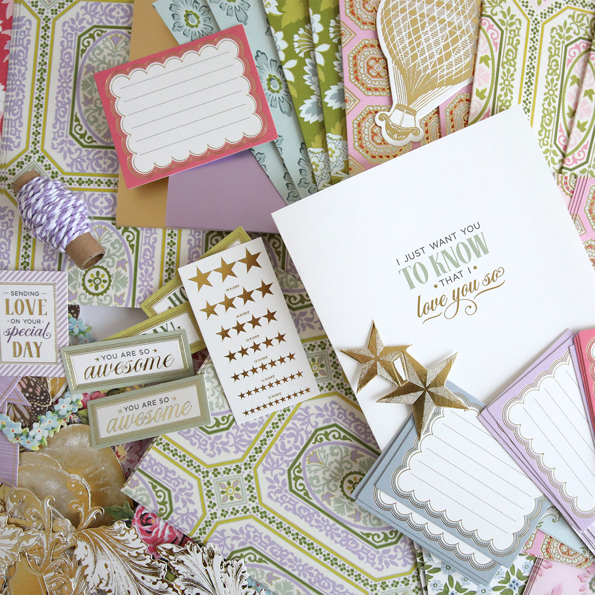 Assorted items from the Charlie Ultimate Paper Crafting Collection—layered paper crafts, message cards, star stickers, and decorative tags—are arranged on a flat surface.