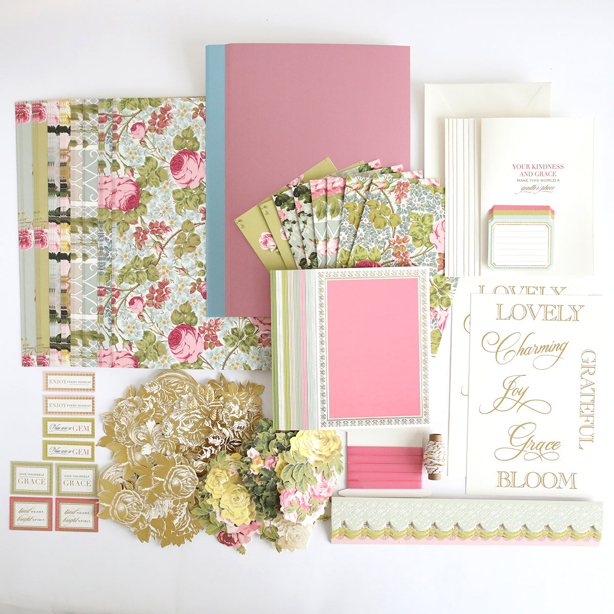 The Rose Ultimate Paper Crafting Collection includes floral patterned papers, envelopes, cards, gold embellishments, tags, and decorative labels—perfect for card making and paper crafting—all arranged on a white surface.