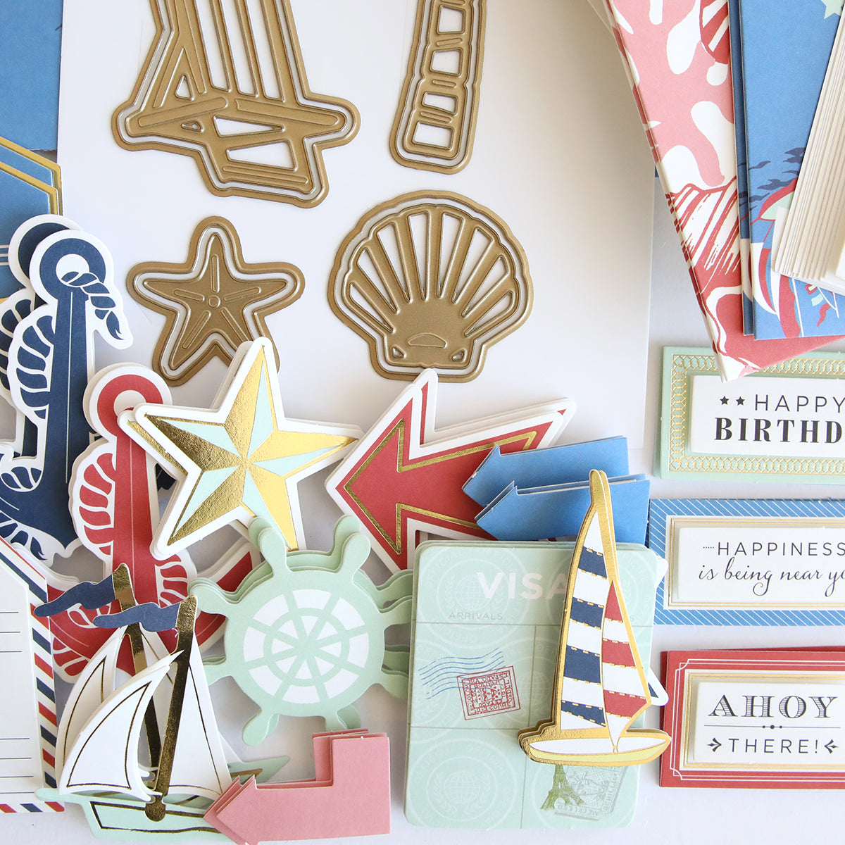Seafarer Papercrafting Kit with Dies: This kit features assorted nautical-themed paper craft decorations, such as gold metal shapes, arrows, shells, a sailboat, a ship wheel, stars, and colorful tags with birthday or travel motifs—ideal for any seafarer’s papercrafting or nautical card making projects. Coordinating dies are included for effortless creativity.