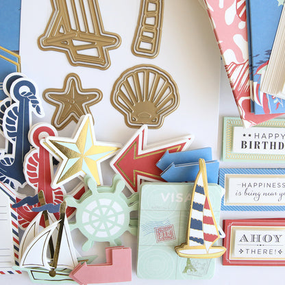 Seafarer Papercrafting Kit with Dies: This kit features assorted nautical-themed paper craft decorations, such as gold metal shapes, arrows, shells, a sailboat, a ship wheel, stars, and colorful tags with birthday or travel motifs—ideal for any seafarer’s papercrafting or nautical card making projects. Coordinating dies are included for effortless creativity.
