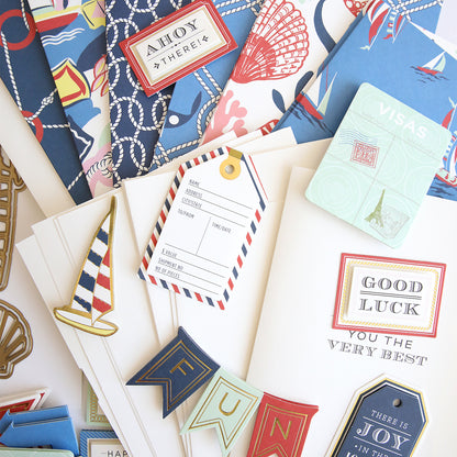 The Seafarer Papercrafting Kit with Dies includes stationery items featuring nautical designs such as cards, tags, and banners adorned with boats, ropes, and sea motifs—beautifully arranged on a flat surface—making it an ideal addition to any nautical card making kit or collection of coastal scrapbook supplies.