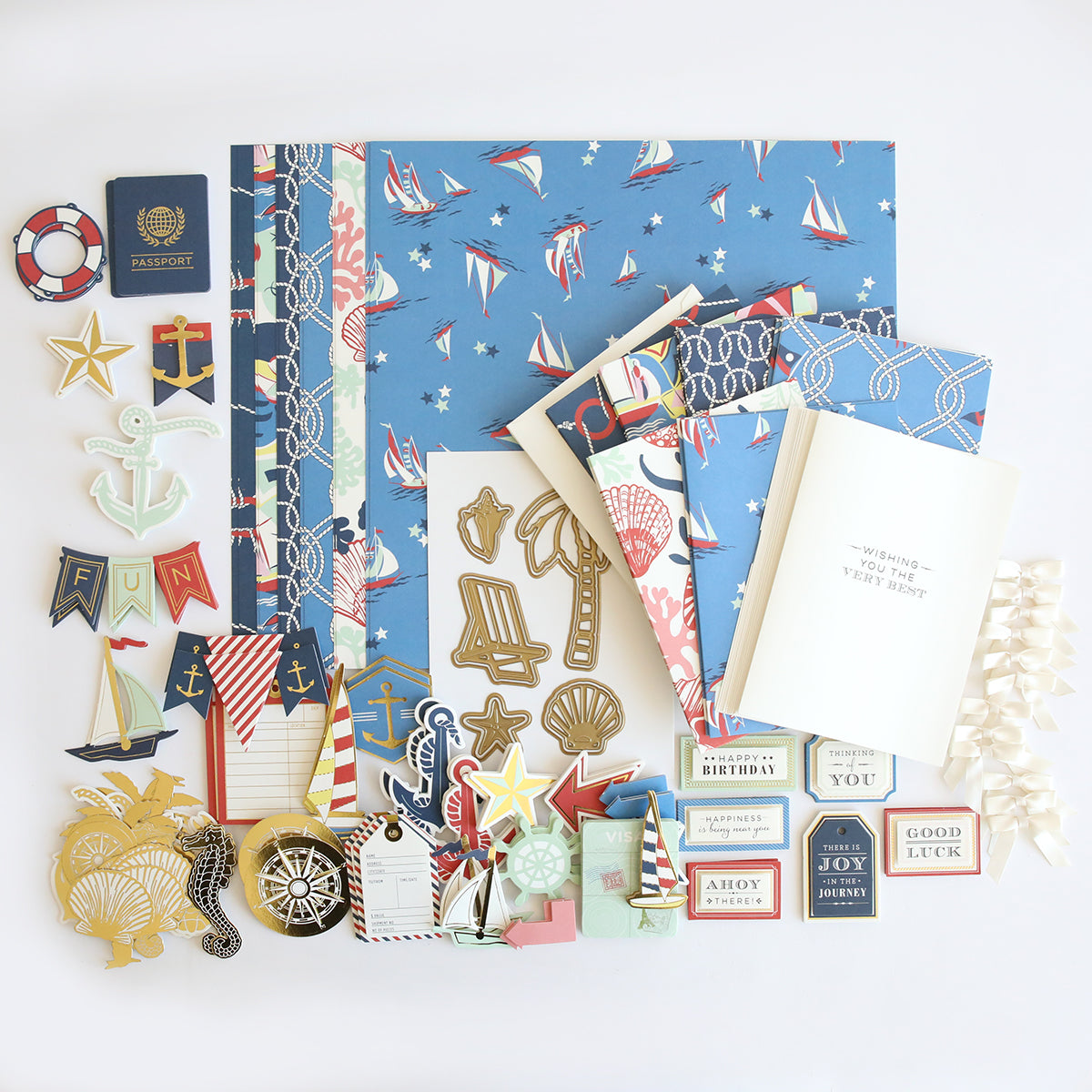 The Seafarer Papercrafting Kit with Dies, featuring nautical-themed patterned paper, dies, stickers, ribbon, and decorative cards, is arranged neatly on a white background.