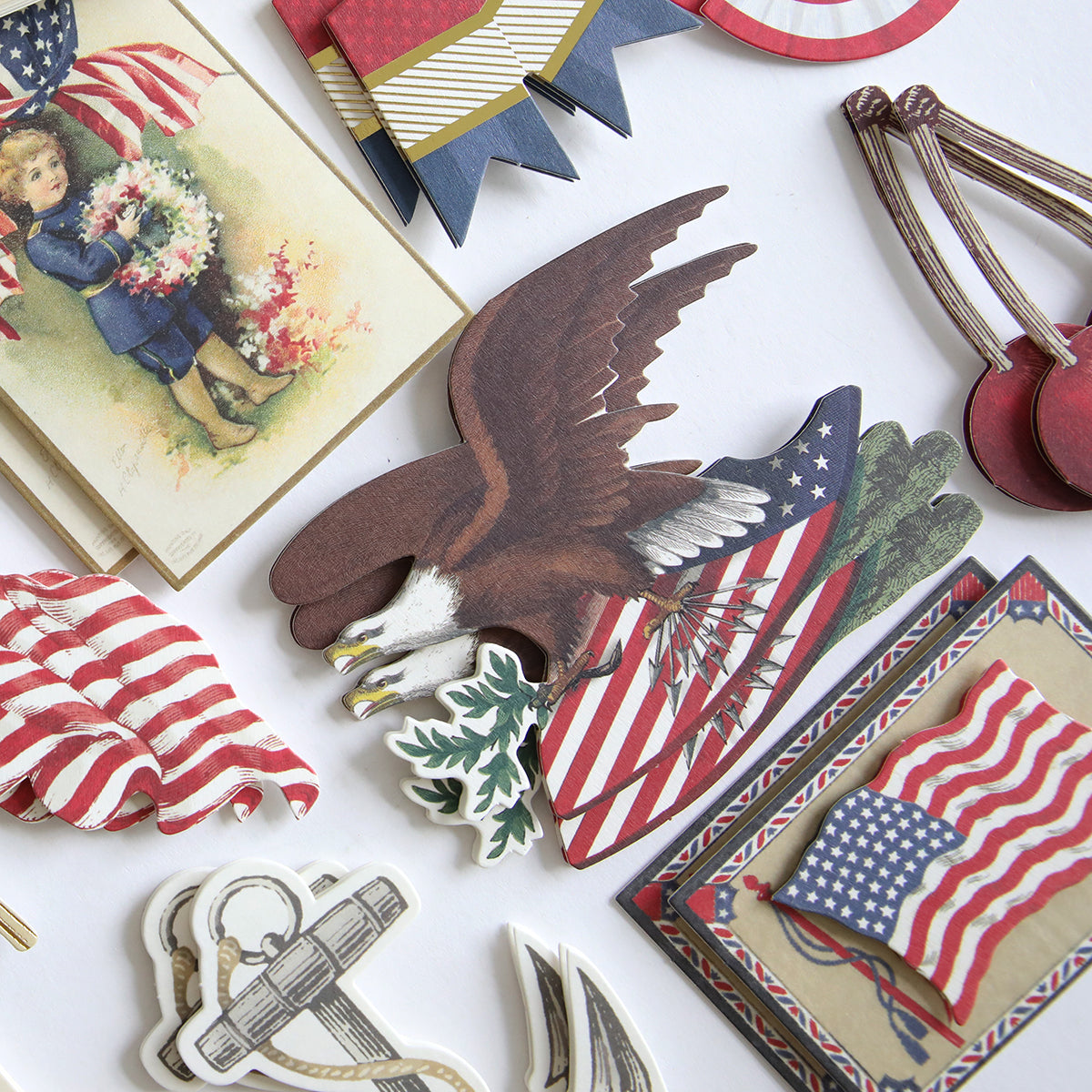The Patriotic Papercrafting Kit with Dies includes vintage Americana paper crafts—flag, eagle, anchor, and a child with flowers—ideal for card making or adding a patriotic touch to your craft projects.
