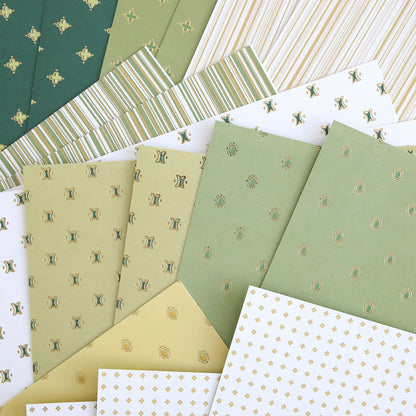 The Lucky for All Double Sided Cardstock is arranged in a fan shape, showcasing green, white, and yellow tones with stripes, dots, and geometric patterns.