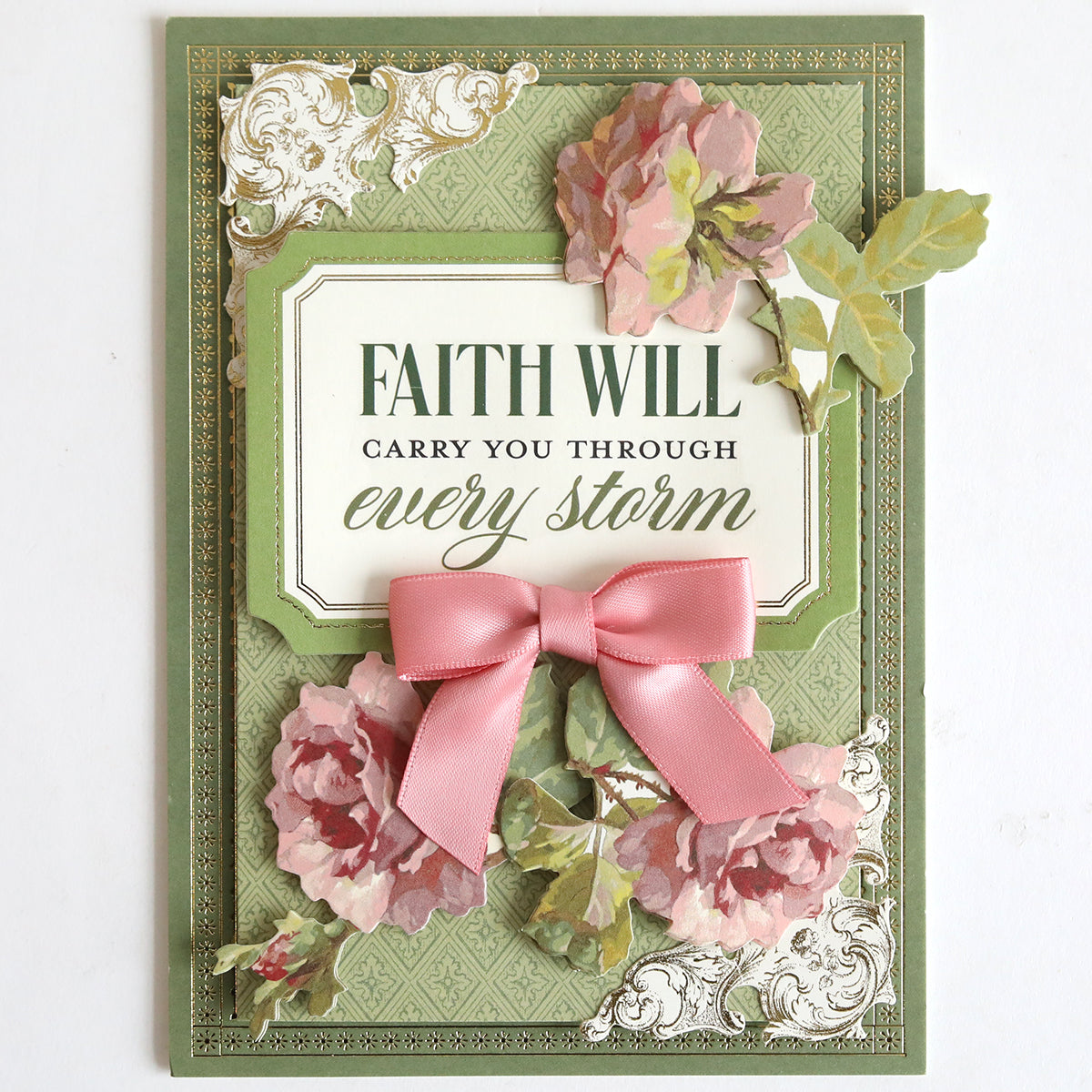 A decorative encouragement card with pink flowers, ribbon, and "Faith will carry you through every storm" on a green background—perfect as a sympathy card or to pair with the Prayer Sentiment Rub On Transfers.