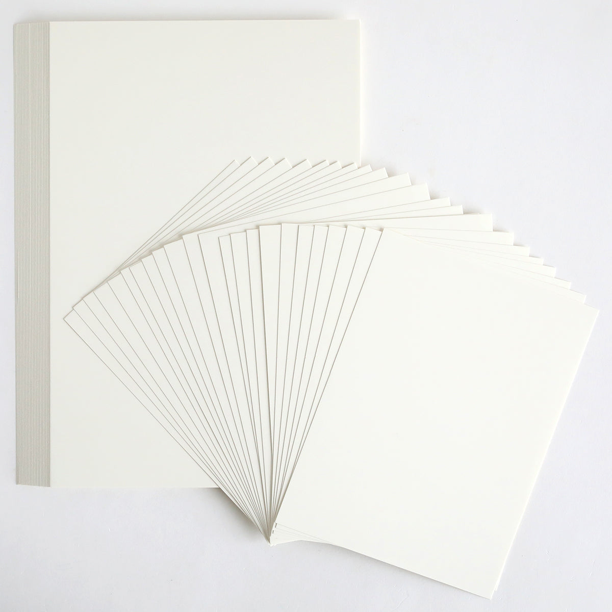 Ivory Coated Cardstock, 260 gsm, shown fanned out on a white surface—ideal for hot foil projects.