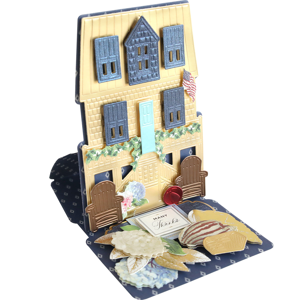 The Summer House 3D Easel Dies create a yellow house with blue shutters, an American flag, flowers, and a "Thanks" message on a dark base—ideal for summer crafting or making standout pop-up greeting cards.