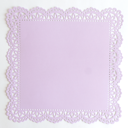 A purple paper doily on a white surface.