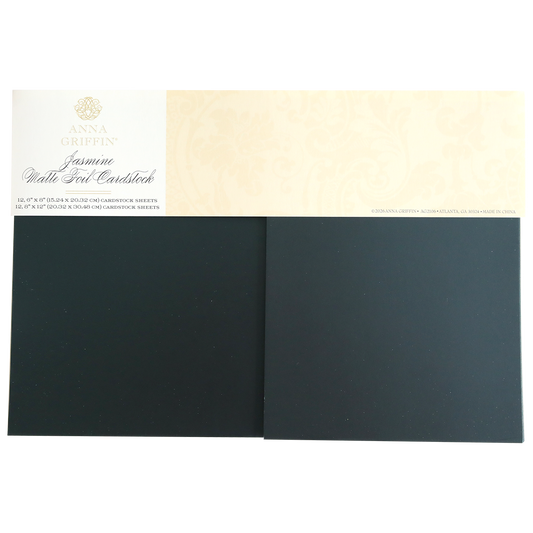 Two black matte Jasmine Matte Foil Cardstock sheets by Anna Griffin, ideal for embossing and die cutting, each topped with a cream-colored branded label.