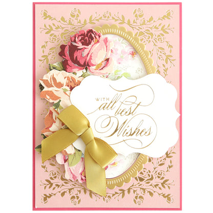 A pink card made with Gilded Rose Frame and Sentiment Hot Foil Plates features a floral border, gold floral accents, paper flowers, a gold ribbon bow, and a “With all best wishes” label in gold script.