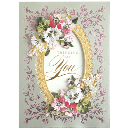 The Rose Garden Frame and Sentiment Gilded Foil Frame Plates create a decorative greeting card with a gold rose frame, floral accents, and "Thinking of You" on a pale pink vine background—ideal for elegant paper crafts.