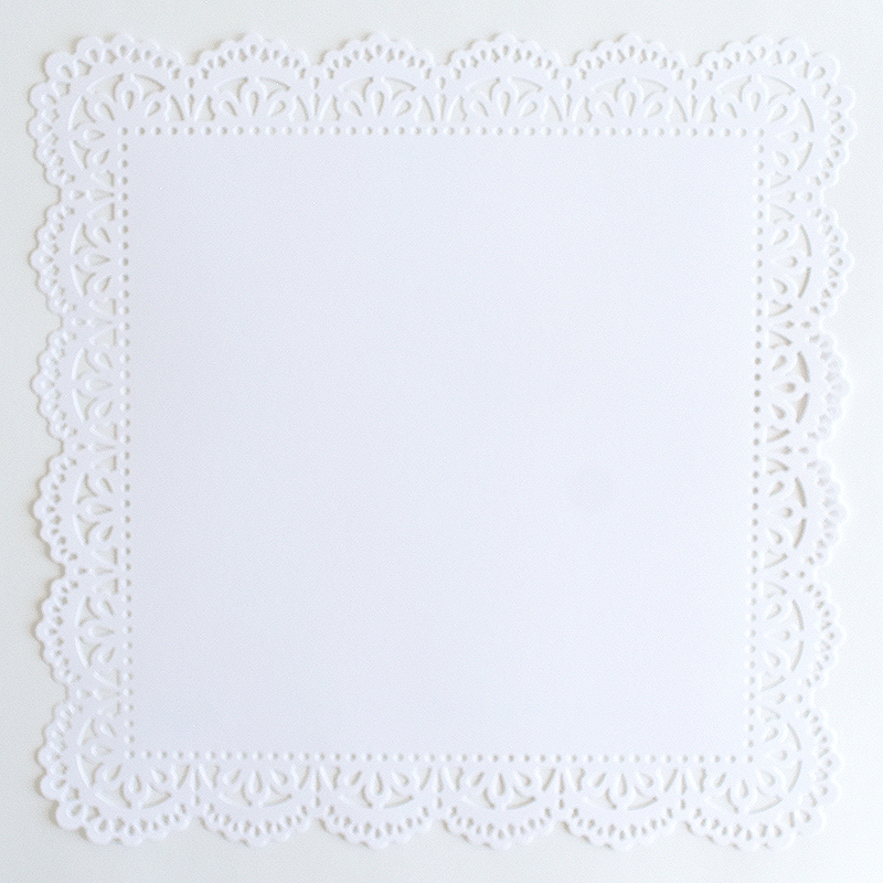 A white paper doily on a white surface.