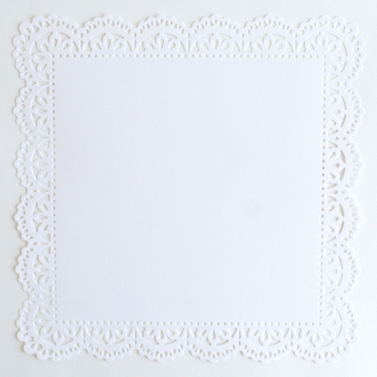 A white paper doily on a white surface.