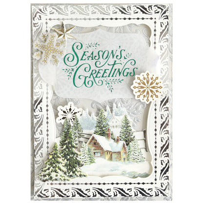 Send warm Christmas wishes with the Gilded Christmas Frame and Sentiments Hot Foil Plate, featuring "Season's Greetings" in green, snowflakes, snowy pine trees, a cottage scene, and an elegant silver border—ideal for handmade holiday cards.