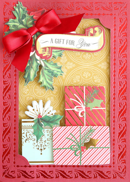 A red and gold greeting card featuring a red bow, holly leaves, and three wrapped gifts with the text “A Gift For You” at the top—ideal for Christmas card making or crafting with double-sided Holiday Color Drenched Cardstock.