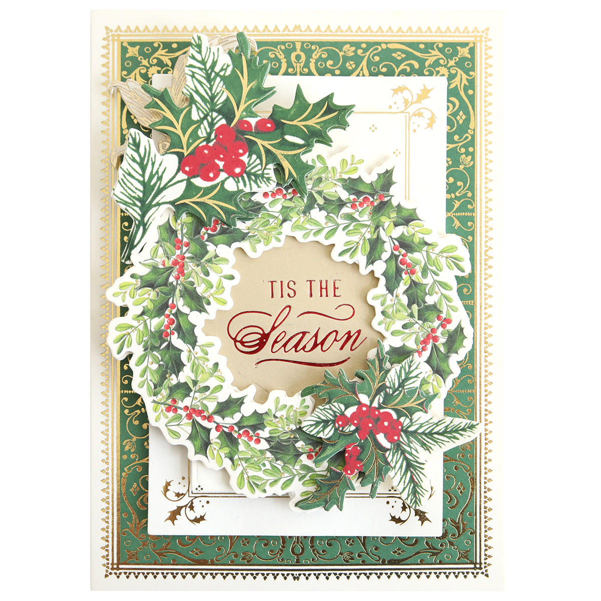 A greeting card featuring a decorative green wreath with holly and red berries, encircling the phrase “Tis the Season.” The background showcases gold accents on a green and white border, lending an elegant touch ideal for handmade crafts. You can use the Gilded Small Sentiments Foil Plates Bundle or other hot foil plates to achieve this festive effect.