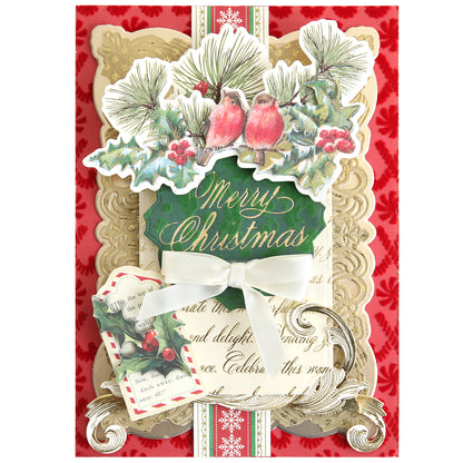 Send festive greetings with this decorative Christmas card, featuring “Merry Christmas” text, red birds, pine branches, holly, gold accents created using the Gilded Small Christmas Sentiments Hot Foil Plates, and a white ribbon bow—all set against a red patterned background.