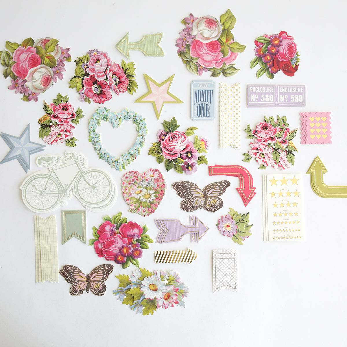 Charlie Die Cut Embellishments: a set of decorative paper cutouts featuring flowers, arrows, stars, butterflies, a bicycle, tickets, hearts, and banners—perfect for adding flair to scrapbooks or as die cut embellishments.