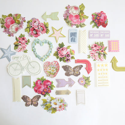 Charlie Die Cut Embellishments: a set of decorative paper cutouts featuring flowers, arrows, stars, butterflies, a bicycle, tickets, hearts, and banners—perfect for adding flair to scrapbooks or as die cut embellishments.