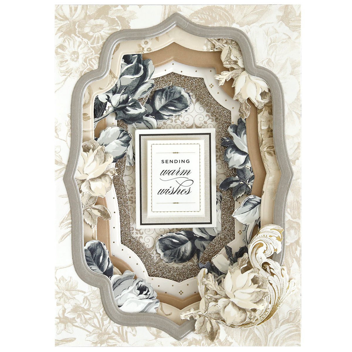 A layered ornate frame, crafted with the Concentric Shape Dies Bundle (all 4 sets) and embellished with white and gray floral accents, surrounds a card featuring “Sending warm wishes” in elegant script.