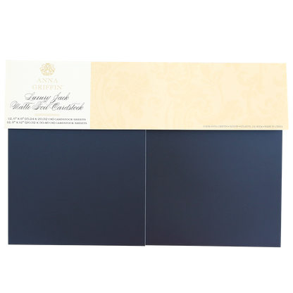 A pack of Luxury Jack Matte Foil Cardstock includes two sheets of dark blue matte foil cardstock with a beige label on top—ideal for handmade cards and scrapbooking projects.