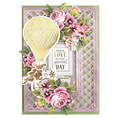 Decorative greeting card crafted from Luxury Charlie Matte Foil Cardstock, featuring a gold hot air balloon, pink flowers, and “Sending love on your special day” on a lattice background with elegant premium die cuts.