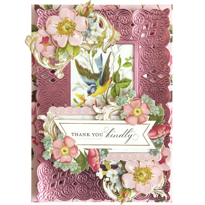 The Dream 3D Frame and Border Dies create an ornate pink greeting card with floral designs, a bird among flowers, and a "Thank you kindly" banner—ideal for paper crafts enthusiasts seeking elegant die-cut detailing.
