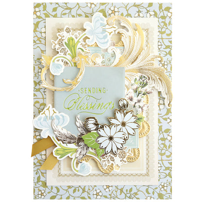 Featuring the "Sending Blessings" message, this greeting card is adorned with layered gold, white, and pastel floral motifs set against an ornate background of lace-inspired green and white patterns. Perfect for handmade card enthusiasts, it showcases the artistry of the Gilded Small Blessings Sentiment Foil Plates and adds a heartfelt touch to any creation.