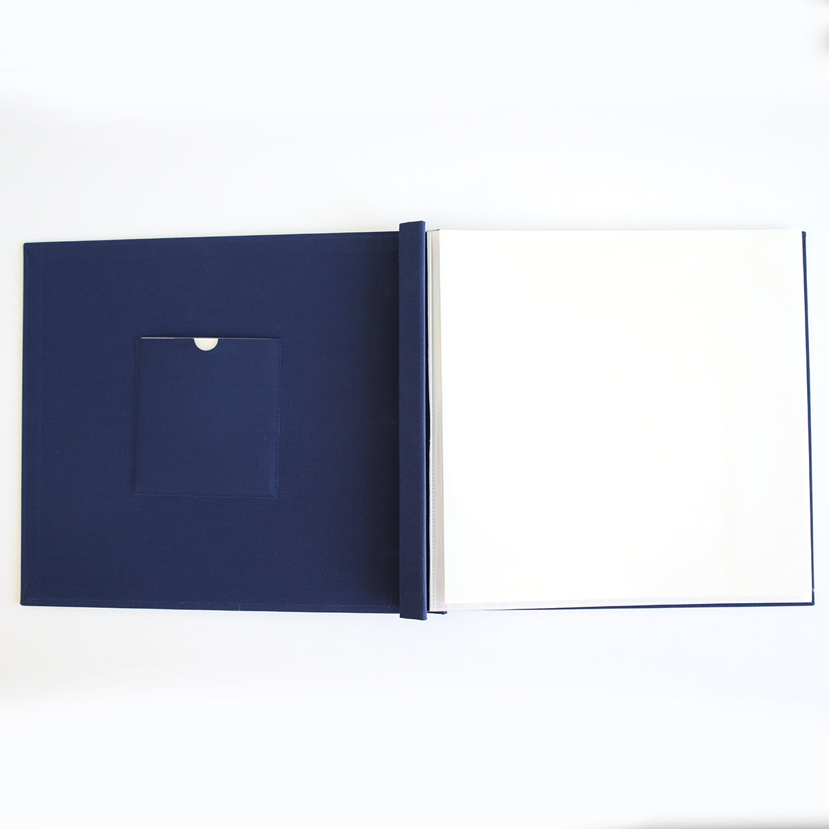 The Jack Navy Post Bound Scrapbook Album is open and empty, showing blank white pages and a small inside cover pocket—ideal for crafting personalized scrapbook layouts, seen from above.
