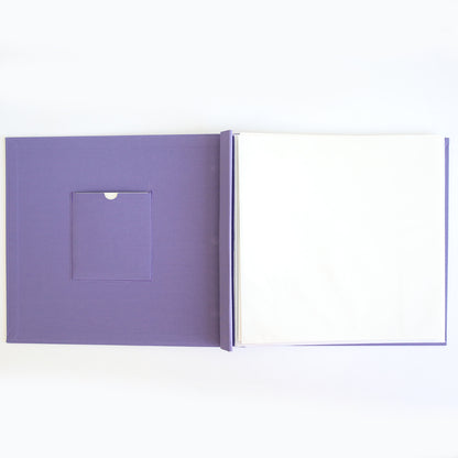 The Charlie Purple Post Bound Scrapbook Album features an open purple hardcover, a small left-side pocket, and blank white pages on the right—ideal for customizing with page protectors.