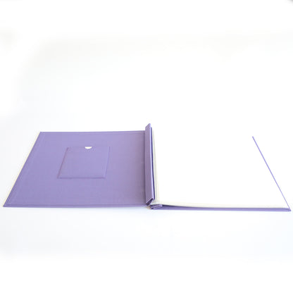 The Charlie Purple Post Bound Scrapbook Album is an open hardcover album with a left-side pocket and blank white pages on the right, displayed against a white background.