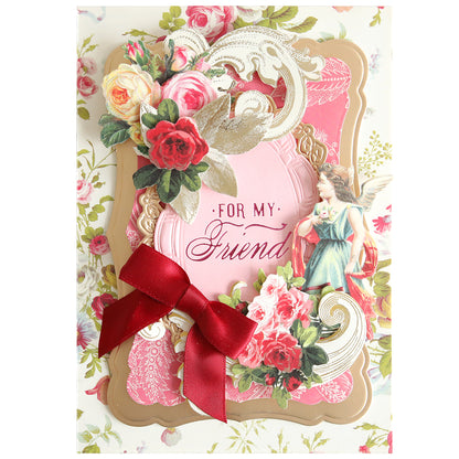 Greeting card featuring floral and angel motifs, adorned with a red bow and the message “For My Friend” at the center against a patterned background—an elegant choice for conveying heartfelt birthday or sympathy wishes. Make your gesture even more memorable by pairing this card with the Set of 30 Gilded Small Sentiment Plates for an extra-special touch.