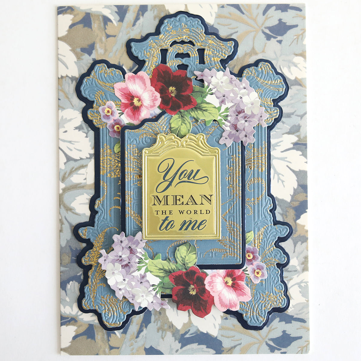 With Gratitude Sentiment Rub Ons feature an ornate blue and gold frame with floral decorations and the heartfelt message “You mean the world to me” on a beautiful patterned background. Perfect for expressing thanks, these rub ons are ideal for papercrafting embellishments or adding a special sentiment to thank you cards, ensuring every project conveys meaningful appreciation.