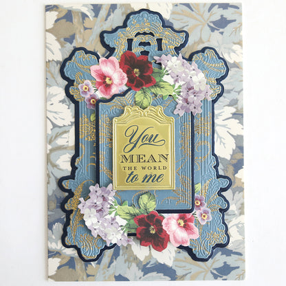 With Gratitude Sentiment Rub Ons feature an ornate blue and gold frame with floral decorations and the heartfelt message “You mean the world to me” on a beautiful patterned background. Perfect for expressing thanks, these rub ons are ideal for papercrafting embellishments or adding a special sentiment to thank you cards, ensuring every project conveys meaningful appreciation.