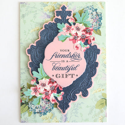 Greeting card with floral decorations and an ornate border, displaying the message: “Your friendship is a beautiful gift.” Perfect for pairing with the With Gratitude Sentiment Rub Ons or incorporating other papercrafting supplies to create heartfelt thank you card sentiments.