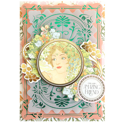 Greeting card featuring an ornate, layered floral design created with handmade card techniques, showcasing a vintage-style portrait of a woman at the center beautifully accentuated by Gilded Art Nouveau Border & Pattern Hot Foil Plate details from Anna Griffin, and finished with a round label that reads “To an Amazing Friend” in decorative text.