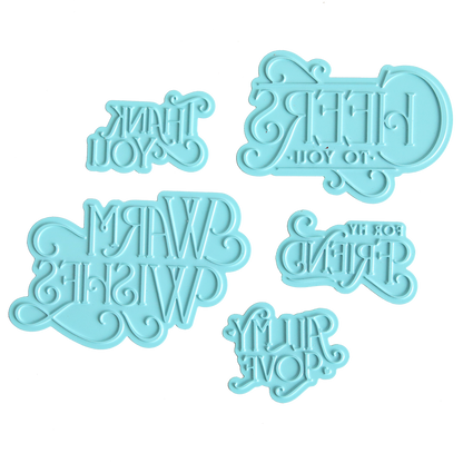 Five light blue Gilded Essential Sentiments Foil Plates featuring reversed text with phrases such as “CHEERS TO YOU!” and “THANK YOU” are displayed on a white background—ideal for adding unique touches to handmade cards or elevating your next paper crafting project.