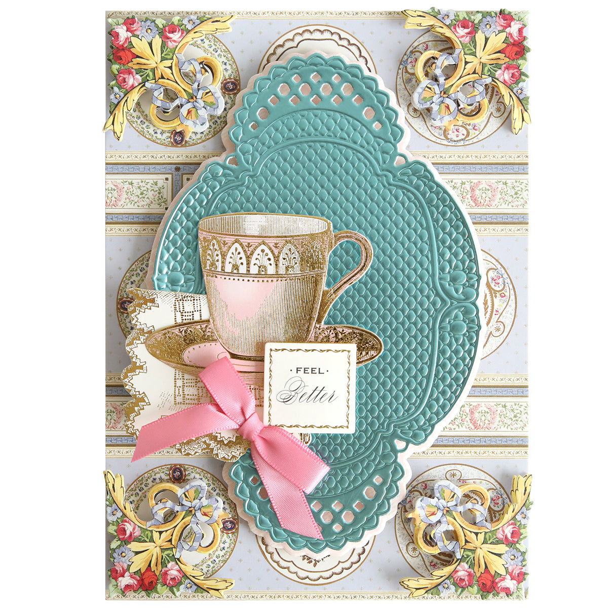Greeting card featuring a teacup illustration, ornate embossed patterns, gold accents, and a pink ribbon with the phrase “FEEL better” on a small square tag in the center—created using Oval Pattern 3D Layer Dies.