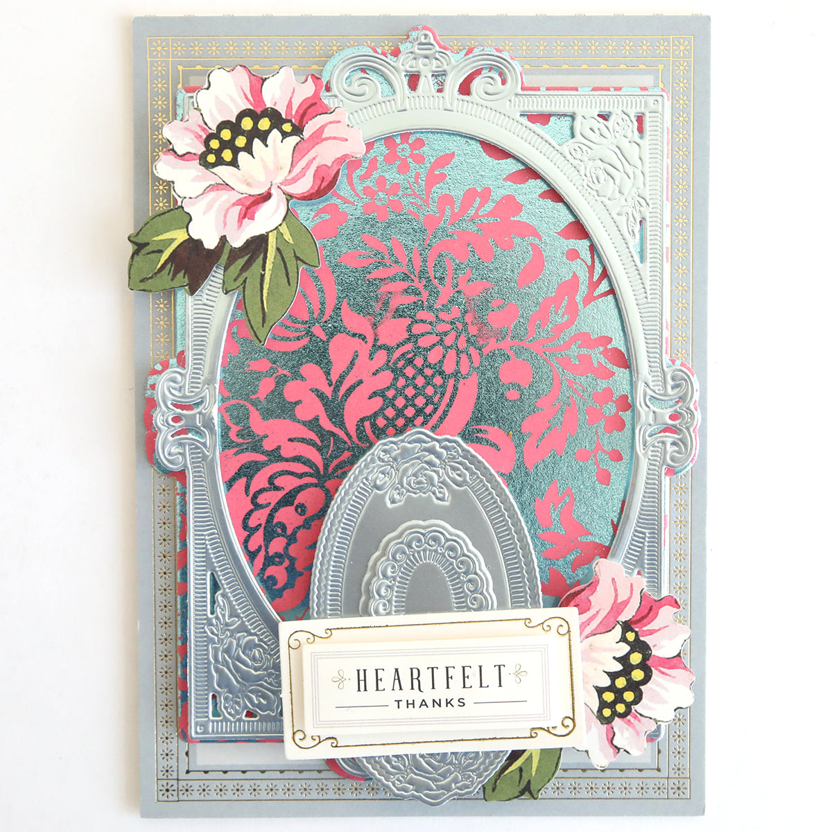 The Gilded Solid Foil Plate 4x6 creates cards with ornate silver embossing and pink floral accents, featuring a "Heartfelt Thanks" label—ideal for card making or pairing with metallic backgrounds for added sophistication.