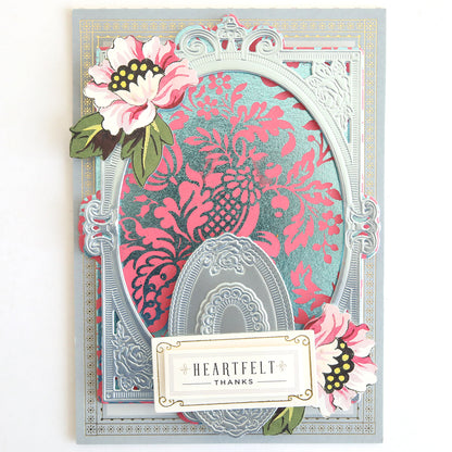 The Gilded Solid Foil Plate 4x6 creates cards with ornate silver embossing and pink floral accents, featuring a "Heartfelt Thanks" label—ideal for card making or pairing with metallic backgrounds for added sophistication.