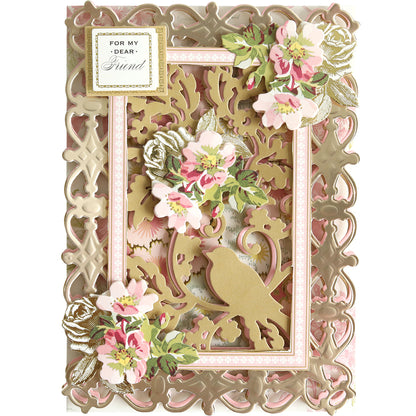 Decorative greeting card crafted with the Bird and Floral Card Front Dies, featuring intricate gold cutout patterns, pink and white floral accents, and a charming bird design. A label in the upper left corner reads “For My Dear Friend.”.