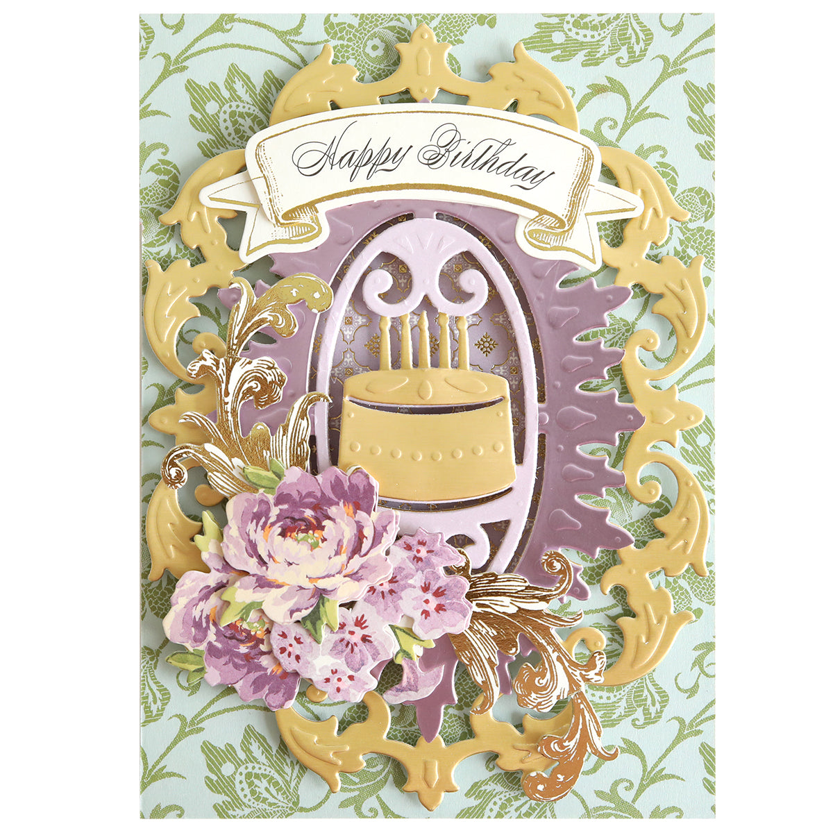 Handmade birthday card featuring an ornate gold frame, a birthday cake die-cut made with the Cake and Suit Card Front Dies and a die cutting machine, decorated with purple floral embellishments and a “Happy Birthday” banner on a green damask background.