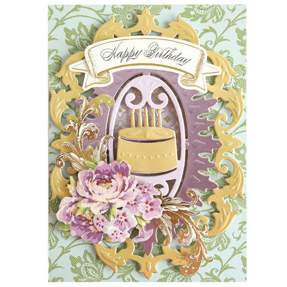 Handmade birthday card featuring an ornate gold frame, a birthday cake die-cut made with the Cake and Suit Card Front Dies and a die cutting machine, decorated with purple floral embellishments and a “Happy Birthday” banner on a green damask background.
