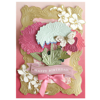 Greeting card created with Dahlia, Mum, and Sunflower 3D Floral Dies features an embossed gold frame, intricate botanical details with flowers and a butterfly, and a pink ribbon bow. A “Happy Birthday” banner is displayed across the center.