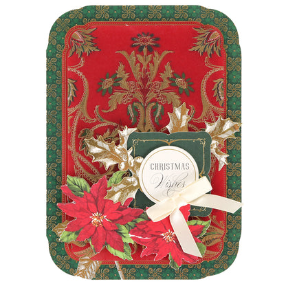 The Simply Merry Christmas Card Making Kit includes red and green cards with gold details, poinsettias, holly leaves, a white ribbon, and a “Christmas Wishes” tag.