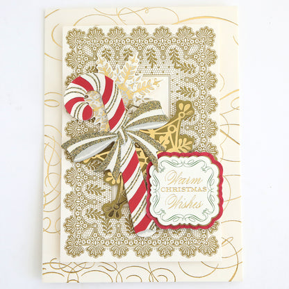 A decorative Christmas card adorned with Favorite Christmas Sentiment Stickers, featuring a gold lace pattern, a striped candy cane, gold snowflake, and a tag that reads “Warm Christmas Wishes.”.