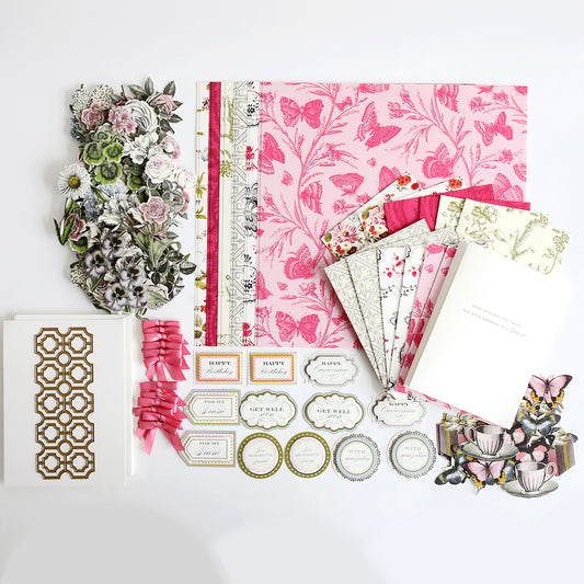 A flat lay of floral stickers, patterned paper, greeting cards, ribbons, tags, and layered embellishments from the Engraved Botanica Kit with Dies—ideal for bringing botanical beauty to your handmade projects.