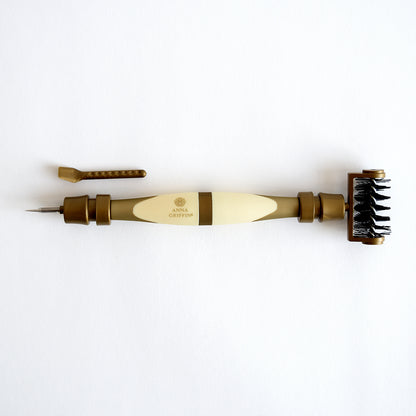 The Diecutting Essential Tools is a craft tool in brown and cream colors that features dual ends: one side has a pointed tip and the other side is equipped with a brush, making it ideal for diecutting and embossing projects.
